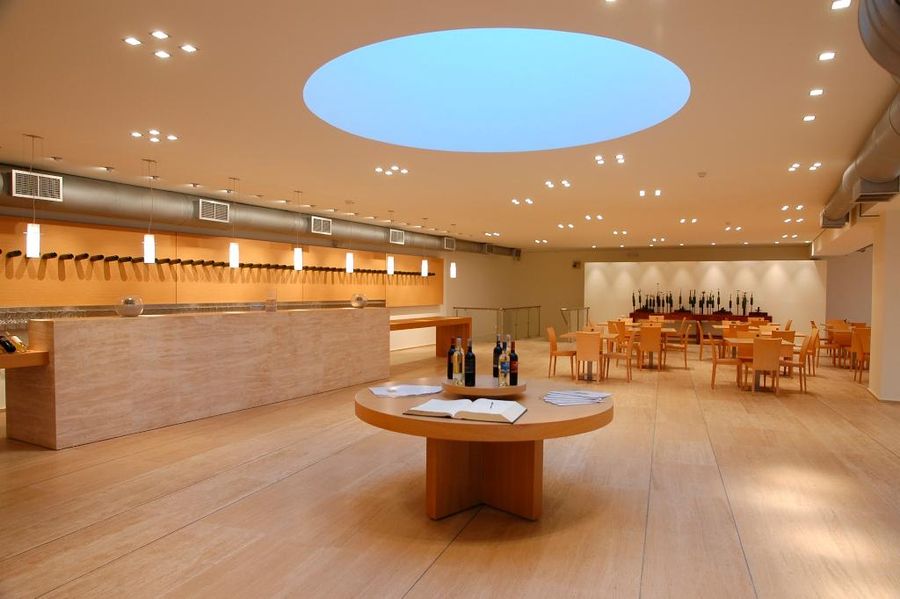 illuminated tasting room at Boutari Crete Winery with tables and chairs and a bar in the background